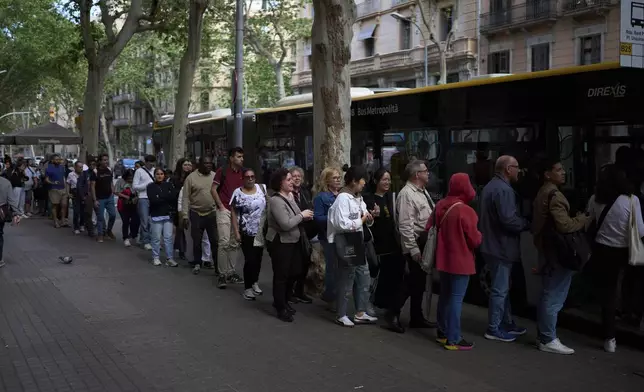 People board on a bus, during a major power outage in Barcelona, Spain, Monday, April 28, 2025. (AP Photo/Emilio Morenatti)