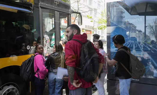 People fail to board a crowded bus after the subway stopped running following a power outage in Lisbon, Portugal, Monday, April 28, 2025. (AP Photo/Armando Franca)