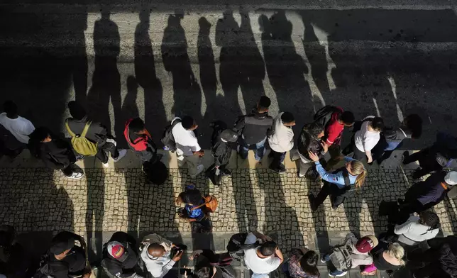 Passengers queue at Oriente transportation hub during a nationwide power outage in Lisbon, Monday, April 28, 2025. (AP Photo/Armando Franca)