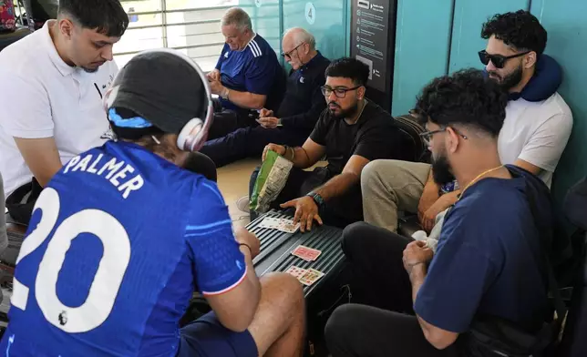 Passengers play cards at Lisbon Airport during a nationwide power outage in Lisbon, Monday, April 28, 2025. (AP Photo/Armando Franca)