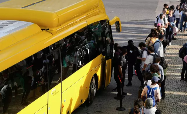 Private security controls passengers boarding buses at Oriente transportation hub during a nationwide power outage that stopped trains and subway in Lisbon, Monday, April 28, 2025. (AP Photo/Armando Franca)