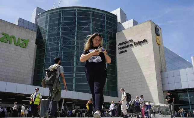 Passengers outside Lisbon Airport during a nationwide power outage in Lisbon, Monday, April 28, 2025. (AP Photo/Armando Franca)