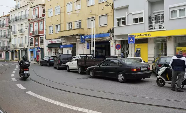 People queue for petrol and at an ATM in Lisbon, Tuesday, April 29, 2025, the day after a nationwide power outage that shut down gas stations and ATMs. (AP Photo/Armando Franca)