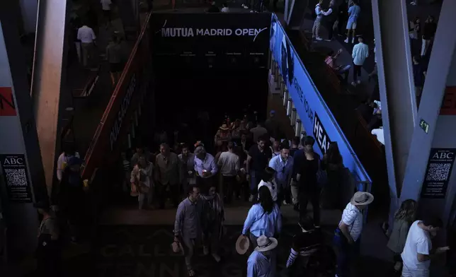 Spectators roam inside the Madrid Open tennis tournament venue during a general blackout in Madrid, Monday, April 28, 2025. (AP Photo/Manu Fernandez)