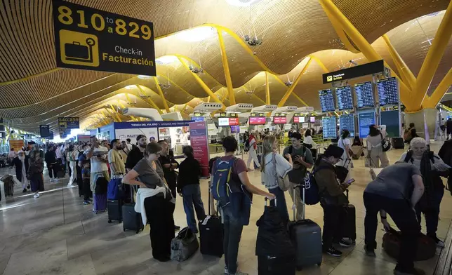 Passengers queue at Madrid airport, during a major power outage, Monday, April 28, 2025. (AP Photo/Manu Fernandez)