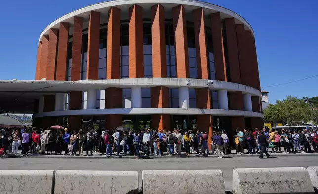 Passengers wait outside Atocha train station during a nationwide power outage in Madrid, Monday, April 28, 2025. (AP Photo/Manu Fernandez)