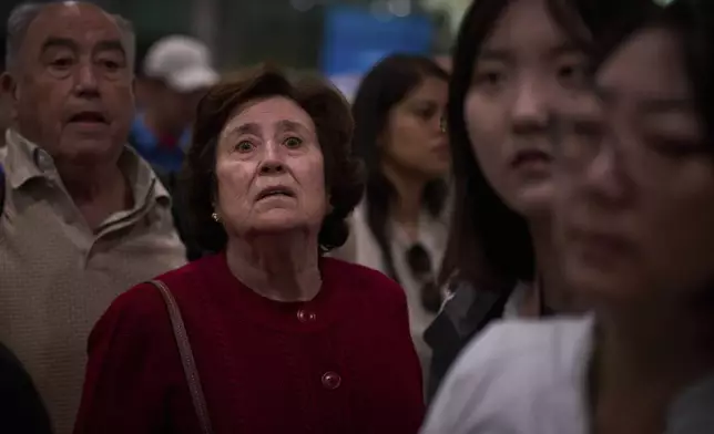 Passengers react as they wait for news of train departures, at Sants train station in Barcelona, Spain, Tuesday, April 29, 2025. (AP Photo/Emilio Morenatti)