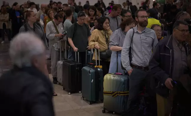Passengers crowd the train accesses at Sants train station in Barcelona, Spain, Tuesday, April 29, 2025. (AP Photo/Emilio Morenatti)