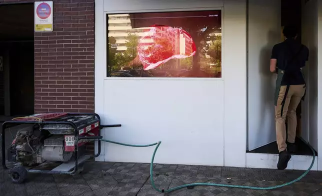 A generator powers a meat shop during a massive power outage in Pamplona, northern Spain, Monday, April 28, 2025. (AP Photo/Miguel Oses)
