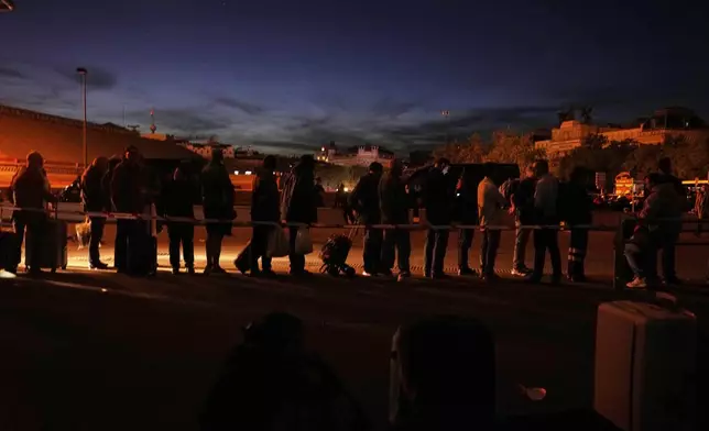People gather outside Atocha train station during a major power outage in Madrid, Monday, April 28, 2025. (AP Photo/Manu Fernandez)