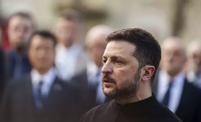 President Volodymyr Zelenskyy answers journalists' questions near a house destroyed by Thursday's Russian strike on a residential neighborhood in Kyiv, Ukraine, on Friday, April 25, 2025. (AP Photo/Evgeniy Maloletka)