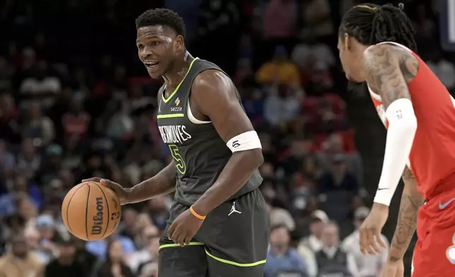 Minnesota Timberwolves guard Anthony Edwards (5) handles the ball against Memphis Grizzlies guard Ja Morant, right, in the first half of an NBA basketball game Thursday, April 10, 2025, in Memphis, Tenn. (AP Photo/Brandon Dill)