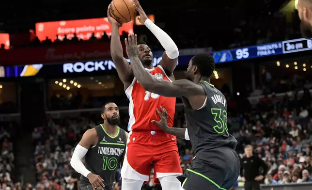 Memphis Grizzlies forward Jaren Jackson Jr., center, shoots between Minnesota Timberwolves forward Julius Randle (30) and guard Mike Conley (10) in the second half of an NBA basketball game Thursday, April 10, 2025, in Memphis, Tenn. (AP Photo/Brandon Dill)