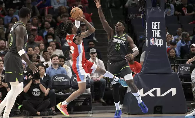 Memphis Grizzlies guard Ja Morant (12) shoots against Minnesota Timberwolves guard Anthony Edwards (5) in the first half of an NBA basketball game Thursday, April 10, 2025, in Memphis, Tenn. (AP Photo/Brandon Dill)