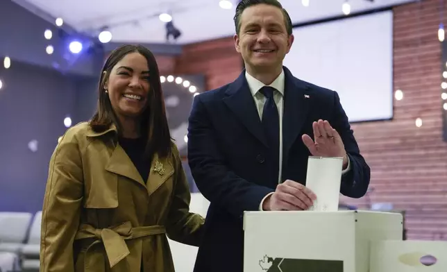 Conservative Leader Pierre Poilievre, right, and his wife Anaida Poilievre cast their votes in the federal election in Ottawa, Canada, Monday, April 28, 2025 in Ottawa. (Adrian Wyld/The Canadian Press via AP)
