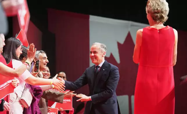 Canadian Prime Minister Mark Carney greets attendees as he arrives to address supporters at his campaign headquarters on election night in Ottawa, Ontario, Tuesday, April 29, 2025. (Nathan Denette/The Canadian Press via AP)