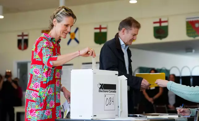 Diana Fox Carney, left, votes in Ottawa, Ontario, Monday, April 28, 2025. (Sean Kilpatrick/The Canadian Press via AP)