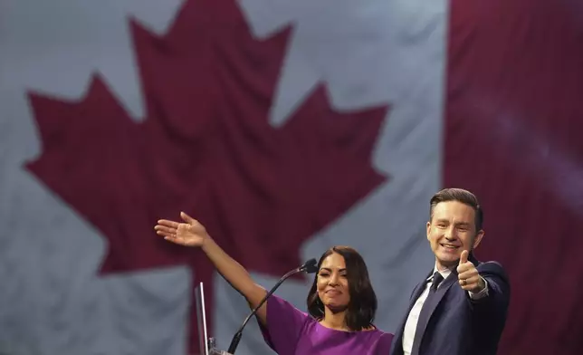 Conservative Leader Pierre Poilievre and his wife Anaida gesture following his speech at his campaign headquarters on election night, in Ottawa, Tuesday, April 29, 2025. (Christinne Muschi/The Canadian Press via AP)