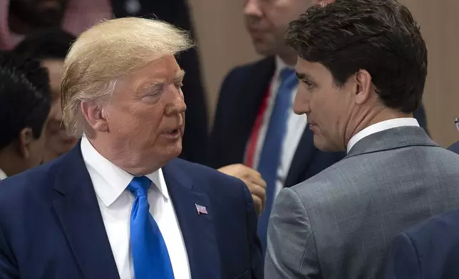FILE - Canadian Prime Minister Justin Trudeau, right, speaks with U.S. President Donald Trump at the start of the a plenary session at the G20 Summit in Osaka, Japan, June 29, 2019. (Adrian Wyld/The Canadian Press via AP, File)