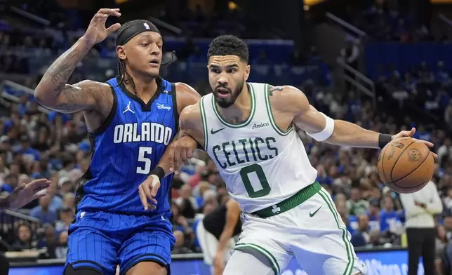 Boston Celtics forward Jayson Tatum (0) tries to get past Orlando Magic forward Paolo Banchero (5) during the first half in game 3 of a first-round NBA playoff basketball series,, Friday, April 25, 2025, in Orlando, Fla. (AP Photo/John Raoux)