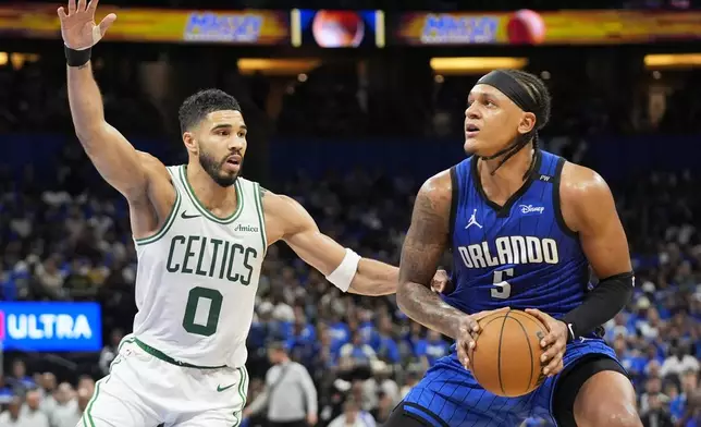 Orlando Magic forward Paolo Banchero, right, lines up a shot against Boston Celtics forward Jayson Tatum (0) during the second half in game 3 of a first-round NBA playoff basketball series,, Friday, April 25, 2025, in Orlando, Fla. (AP Photo/John Raoux)