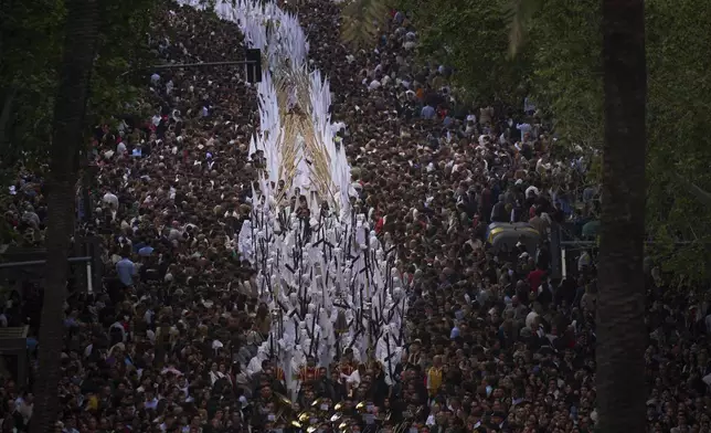 Penitents of 'San Gonzalo' brotherhood process through the streets of Seville during Holy Week in Spain, Monday, April 14, 2025. (AP Photo/Emilio Morenatti)