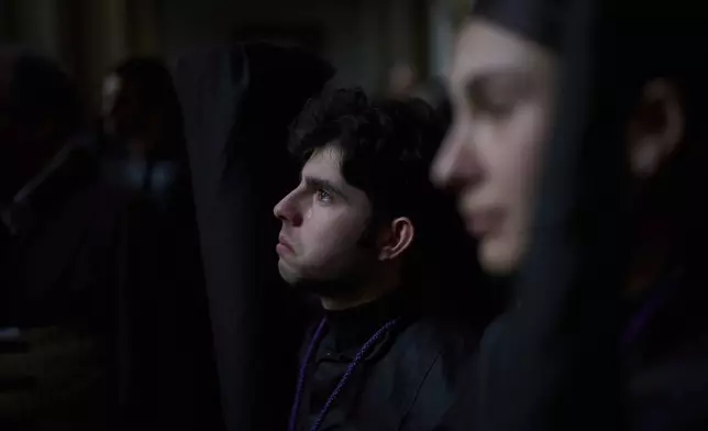 A penitent of the Los Estudiantes brotherhood reacts in tears after being told that they will not go out in procession due to the rain, that has cancelled several processions during Holy Week in Seville, Spain, Tuesday, April 15, 2025. (AP Photo/Emilio Morenatti)
