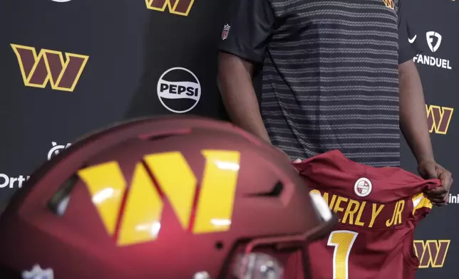 Washington Commanders first-round draft pick offensive tackle Josh Conerly Jr. holds his jersey after an NFL football news conference in Ashburn, Va., Friday, April 25, 2025. (AP Photo/Luis M. Alvarez)