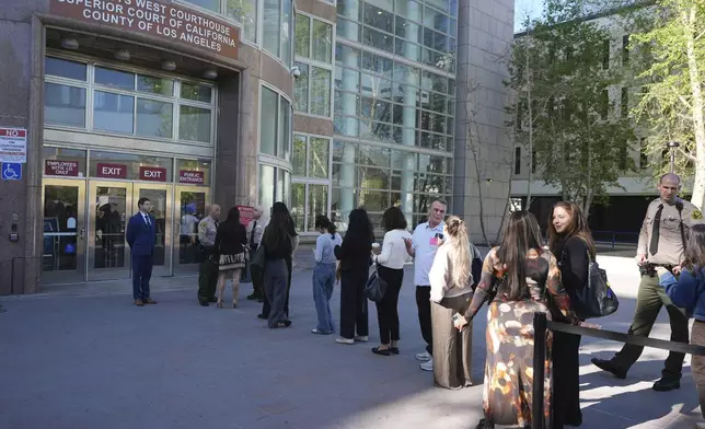 People form a line outside the Van Nuys West Courthouse before a hearing regarding the case of Erik and Lyle Menendez Friday, April 11, 2025, in Los Angeles. (AP Photo/Damian Dovarganes)