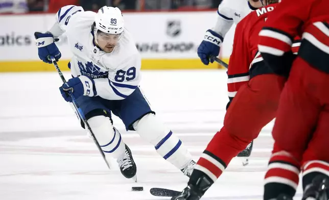 Toronto Maple Leafs' Nicholas Robertson (89) moves the puck against the Carolina Hurricanes during the first period of an NHL hockey game in Raleigh, N.C., Sunday, April 13, 2025. (AP Photo/Karl DeBlaker)