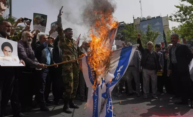 Iranian protesters burn representations of the Israeli flag during a demonstration at the Felestin (Palestine) Sq. in Tehran, Iran, Wednesday, April 9, 2025. (AP Photo/Vahid Salemi)
