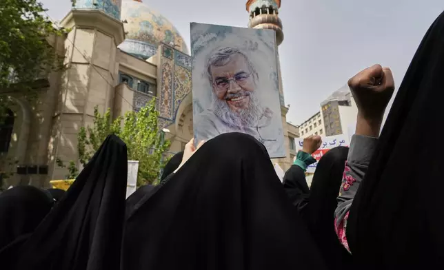 Iranian protesters chant slogans as one of them holds up a poster of Lebanon's Hezbollah former leader Hassan Nasrallah, who was killed by Israel, during an anti-Israeli demonstration at the Felestin (Palestine) Sq. in Tehran, Iran, Wednesday, April 9, 2025. (AP Photo/Vahid Salemi)
