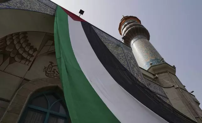 A huge Palestinian flag hangs on a mosque during an anti-Israel protest at the Felestin (Palestine) Sq. in Tehran, Iran, Wednesday, April 9, 2025. (AP Photo/Vahid Salemi)