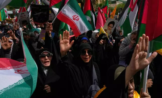 Iranian protesters chant slogans as they wave Iranian and Palestinian flags during an anti-Israel demonstration at the Felestin (Palestine) Sq. in Tehran, Iran, Wednesday, April 9, 2025. (AP Photo/Vahid Salemi)