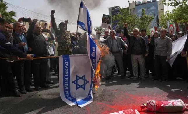Iranian protesters burn representations of the Israeli flag during a demonstration at the Felestin (Palestine) Sq. in Tehran, Iran, Wednesday, April 9, 2025. (AP Photo/Vahid Salemi)