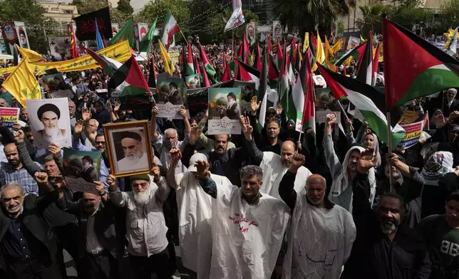Iranian protesters chant slogans as they hold Palestinian flags while some of them wear white shrouds, a symbolic gesture that shows they are prepared to die for their cause, during an anti-Israeli demonstration at the Felestin (Palestine) Sq. in Tehran, Iran, Wednesday, April 9, 2025. (AP Photo/Vahid Salemi)