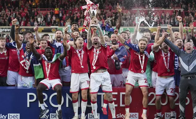 Wrexham players celebrate as they win the English League One soccer match between Wrexham and Charlton Athletic at the Racecourse ground in Wrexham, Wales, Saturday, April 26, 2025. (AP Photo/Jon Super)