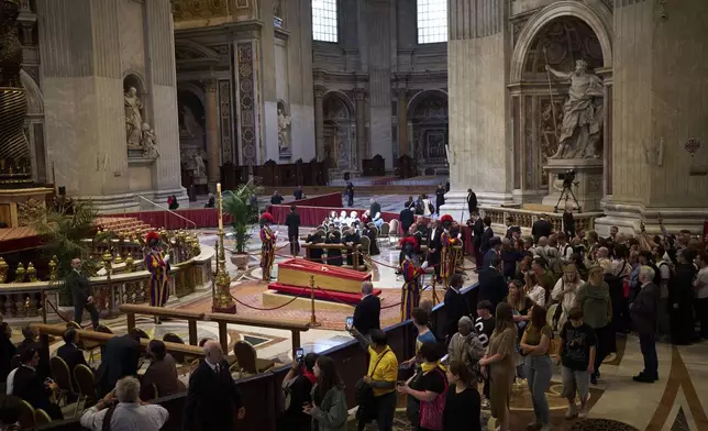 People queue to pay their respect to the late Pope Francis, who will lie in state at St. Peter's Basilica for three days, at the Vatican, Wednesday, April 23, 2025. (AP Photo/Emilio Morenatti)