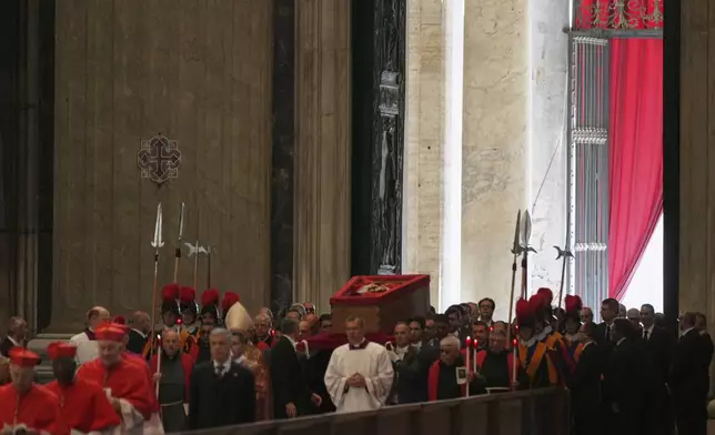 The procession with the body of Pope Francis, who will lie in state for three days, enters St. Peter's Basilica at the Vatican, Wednesday, April 23, 2025. (AP Photo/Francisco Seco)