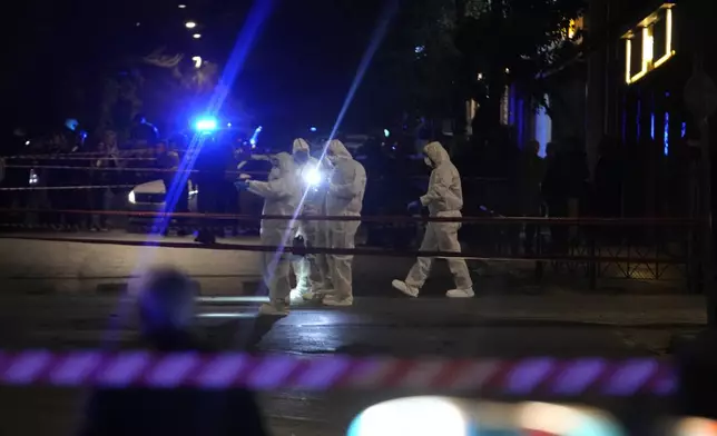 Police officers from the forensics department check the area after a bomb explosion outside of the Hellenic Train offices the company that runs Greece's railway, in Athens, Greece, Friday, April 11, 2025. (AP Photo/Petros Giannakouris)