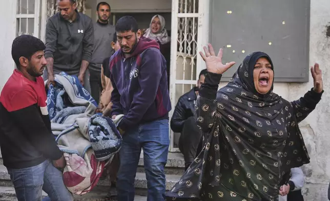 A Palestinian woman reacts as others carry the body of their relative, killed in an Israeli airstrike, in preparation for burial at Shifa Hospital in Gaza City, Wednesday, April 16, 2025. (AP Photo/Jehad Alshrafi)