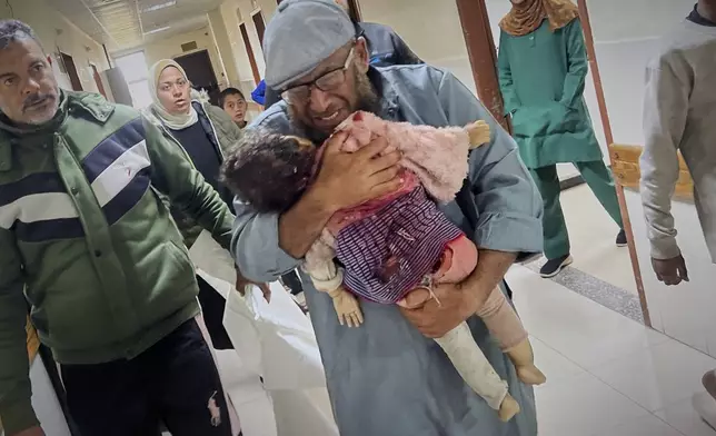 Nashat Seiam carries the body of his granddaughter Ahlam Seiam, who was just days away from her first birthday, into Nasser Hospital, after their home was hit by an overnight Israeli airstrike in Khan Younis, southern Gaza Strip, on Wednesday, April 16, 2025.(AP Photo/Mariam Dagga)