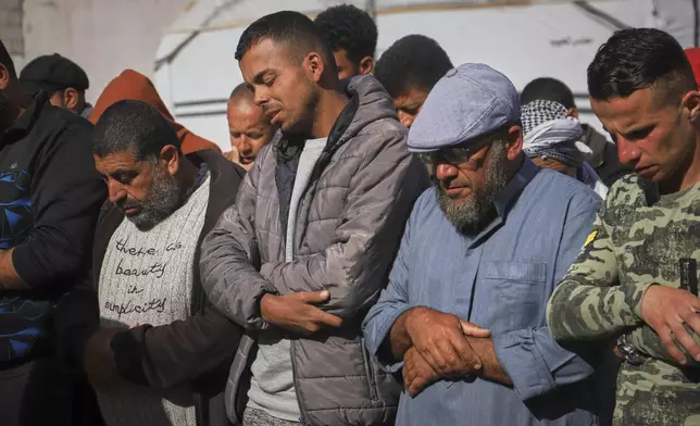 Nashat Seiam, second from right, joins relatives and friends in prayer over the body of his granddaughter Ahlam, who was just days away from her first birthday, during her funeral after she was killed by an overnight Israeli airstrike on her home in Khan Younis, southern Gaza Strip, on Wednesday, April 16, 2025,.(AP Photo/Mariam Dagga)