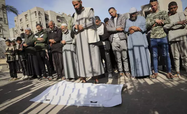 Nashat Seiam, third from right, joins relatives and friends in prayer over the body of his granddaughter Ahlam, who was just days away from her first birthday, during her funeral after she was killed by an overnight Israeli airstrike on her home in Khan Younis, southern Gaza Strip, on Wednesday, April 16, 2025,.(AP Photo/Mariam Dagga)