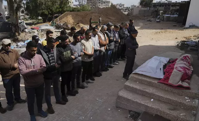 Mourners pray over the bodies of Palestinians killed in an Israeli airstrike during their funeral at Shifa Hospital in Gaza City, Wednesday, April 16, 2025. (AP Photo/Jehad Alshrafi)