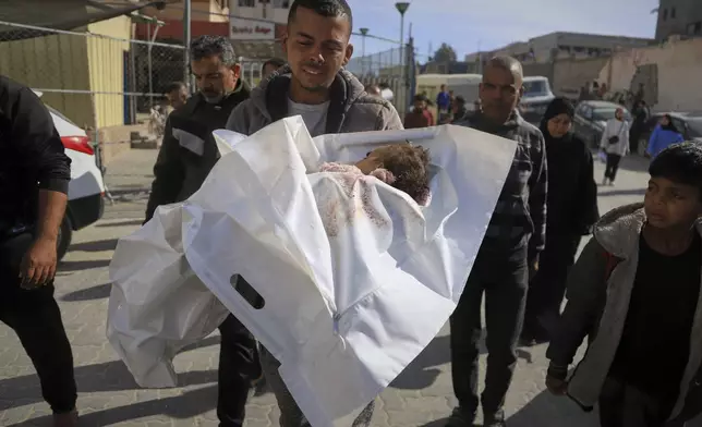 Hosam Seiam carries the body of his niece Ahlam Seiam, who was just days away from her first birthday, into Nasser Hospital, after their home was hit by an overnight Israeli airstrike in Khan Younis, southern Gaza Strip, on Wednesday, April 16, 2025.(AP Photo/Mariam Dagga)