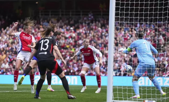 Arsenal's Frida Maanum, left, attempts a header at goal during the women's Champions League semifinals, first leg, soccer match between Arsenal FC and Olympique Lyonnais at the Arsenal Stadium, in London, Saturday, April 19, 2025. (AP Photo/Kirsty Wigglesworth)