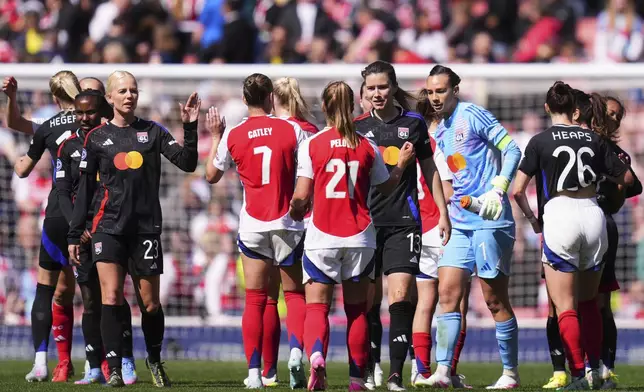 Lyon's Damaris Egurrola, center, greets Arsenal's Victoria Pelova at the end of the women's Champions League semifinals, first leg, soccer match between Arsenal FC and Olympique Lyonnais at the Arsenal Stadium, in London, Saturday, April 19, 2025. (AP Photo/Kirsty Wigglesworth)
