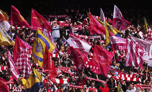 Arsenal fans wave flags on the stands during the women's Champions League semifinals, first leg, soccer match between Arsenal FC and Olympique Lyonnais at the Arsenal Stadium, in London, Saturday, April 19, 2025. (AP Photo/Kirsty Wigglesworth)