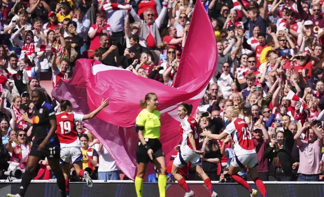Arsenal's Mariona Caldentey, center, celebrates after scoring her side's first goal from the penalty spot during the women's Champions League semifinals, first leg, soccer match between Arsenal FC and Olympique Lyonnais at the Arsenal Stadium, in London, Saturday, April 19, 2025. (AP Photo/Kirsty Wigglesworth)